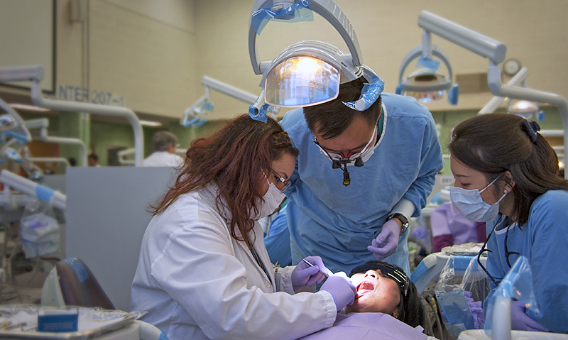 Three dentists working on a patient