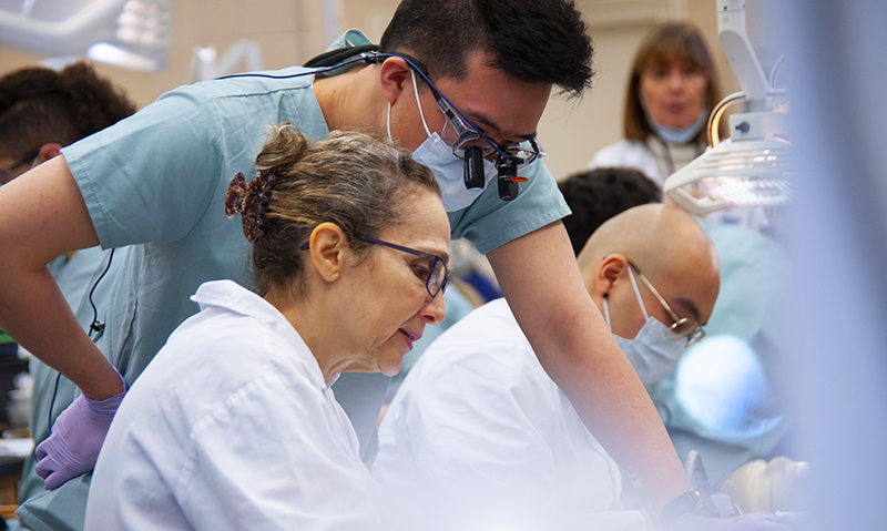 A group of dentists and scientists looking at something together