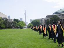 convocation procession while one student looks back at the camera