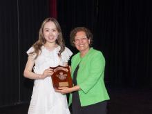 two people smiling and holding award