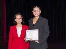 two people smiling and holding award