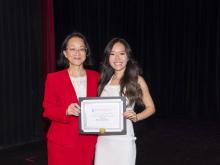 two people smiling and holding award