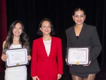 three people smiling and holding award