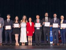 group of people smiling hold awards