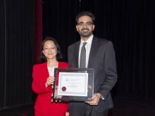 two people smiling and holding award
