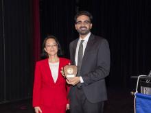 two people smiling and holding award