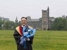 grad student smiling in front of building