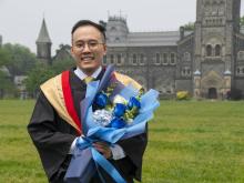 grad student and family smiling in front of building
