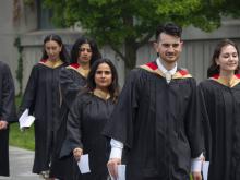graduate students walking in robes