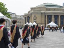 graduate students walking in robes