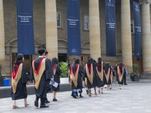 graduate students walking in robes