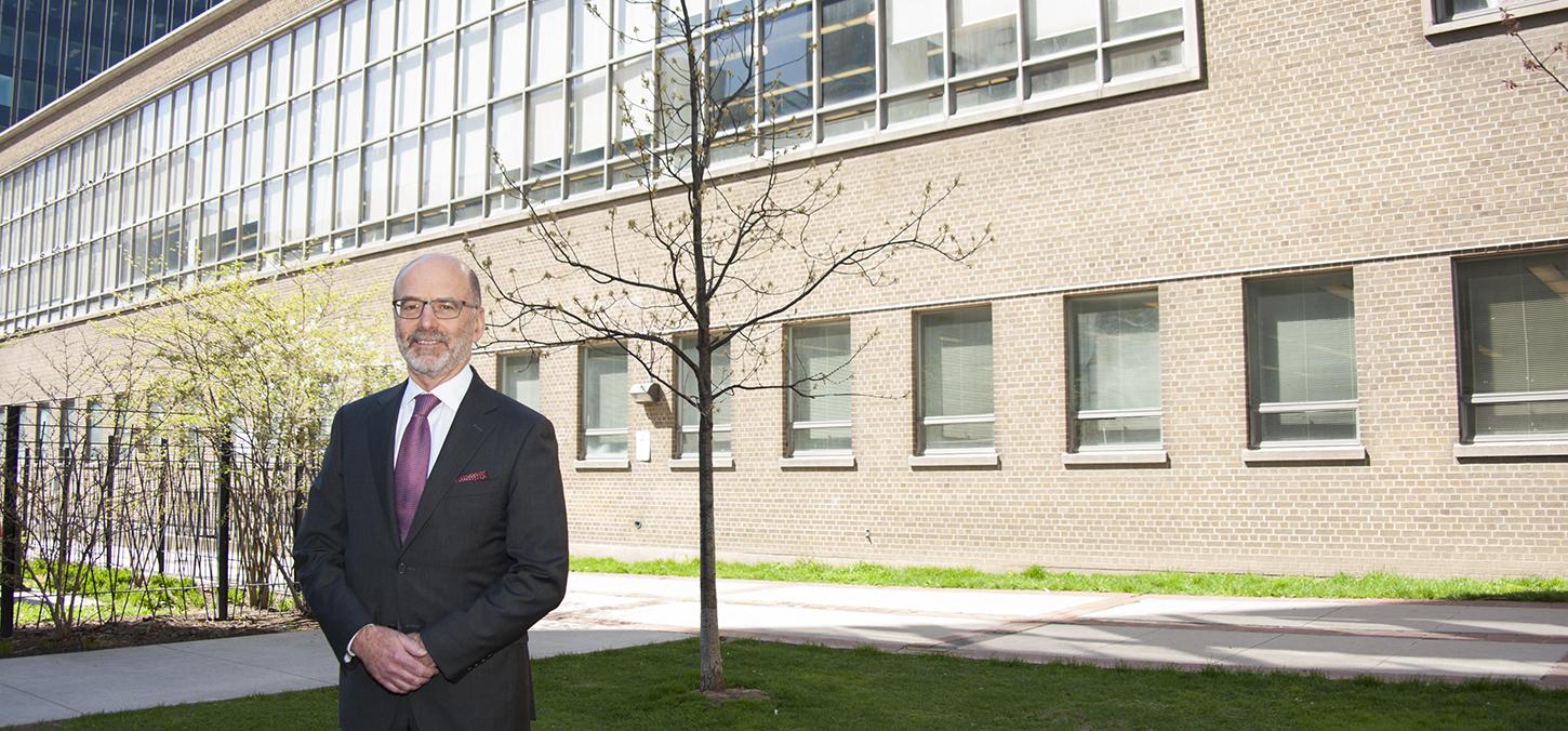 Dean Daniel Haas stands before Dentistry building