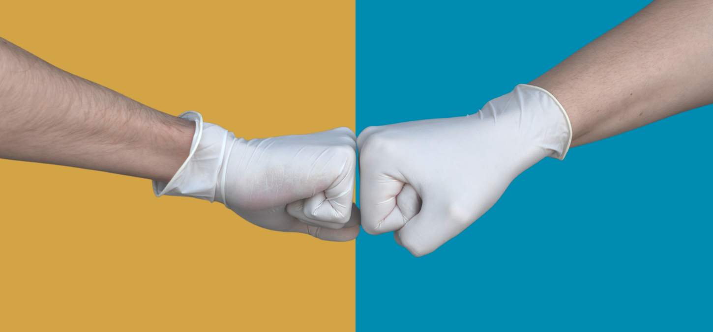 Hands fist bumping with surgical gloves
