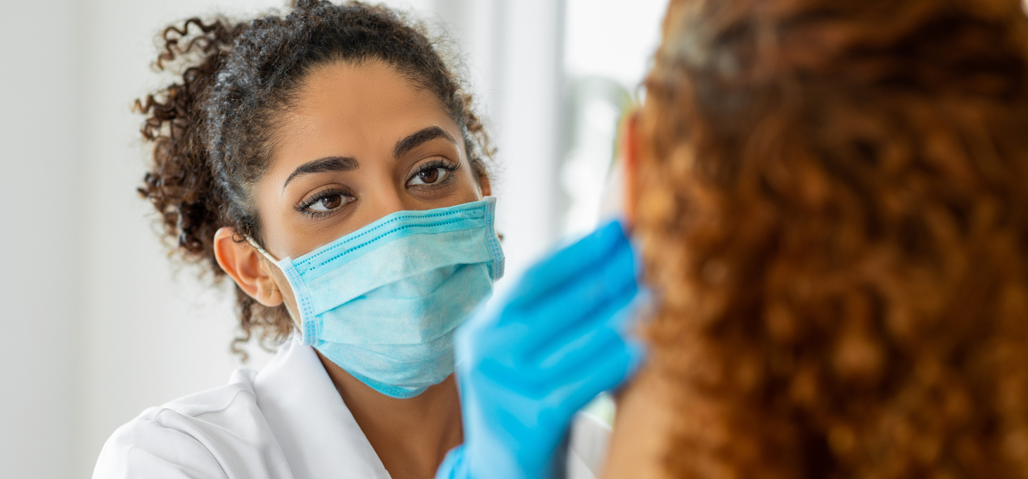 dentist wearing surgical mask examining patient