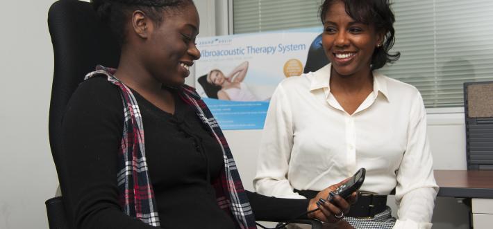 image of patient in vibroacoustic chair with Alicia Howard 
