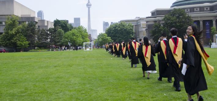 student procession to convocation hall 2017, one woman looks back