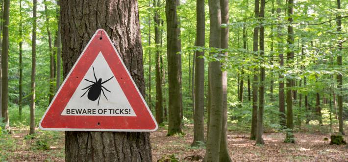 beware of ticks caution sign