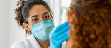 dentist wearing surgical mask examining patient